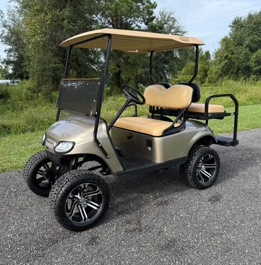 Lifted gold golf cart with custom wheels
