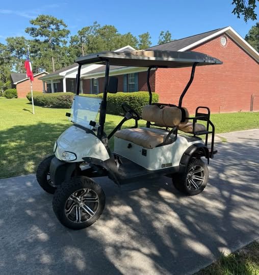 Lifted white golf cart with custom wheels