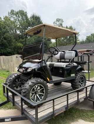 Lifted black golf cart on a trailer